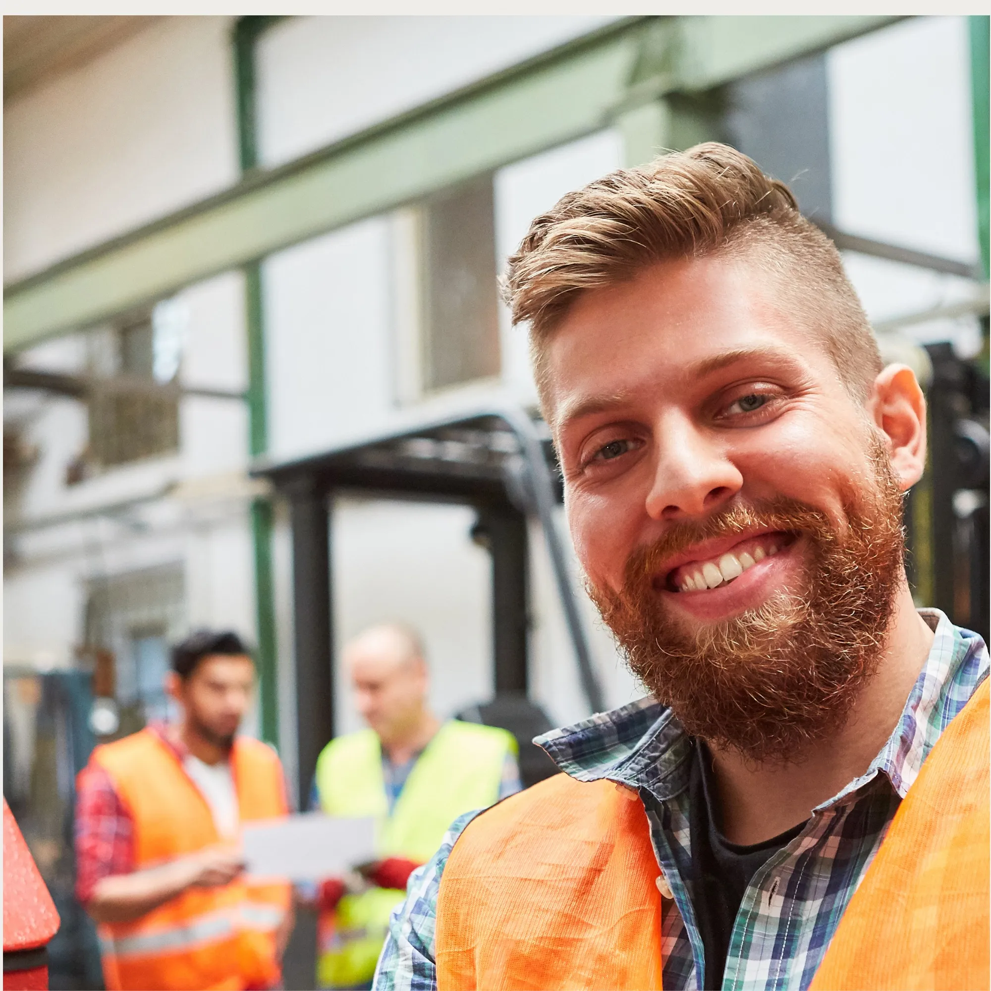 Smiling construction field leader in a hi-vis vest on site