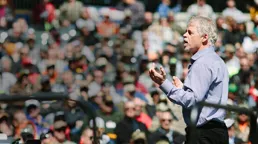Mark Breslin speaking to a large outdoor audience